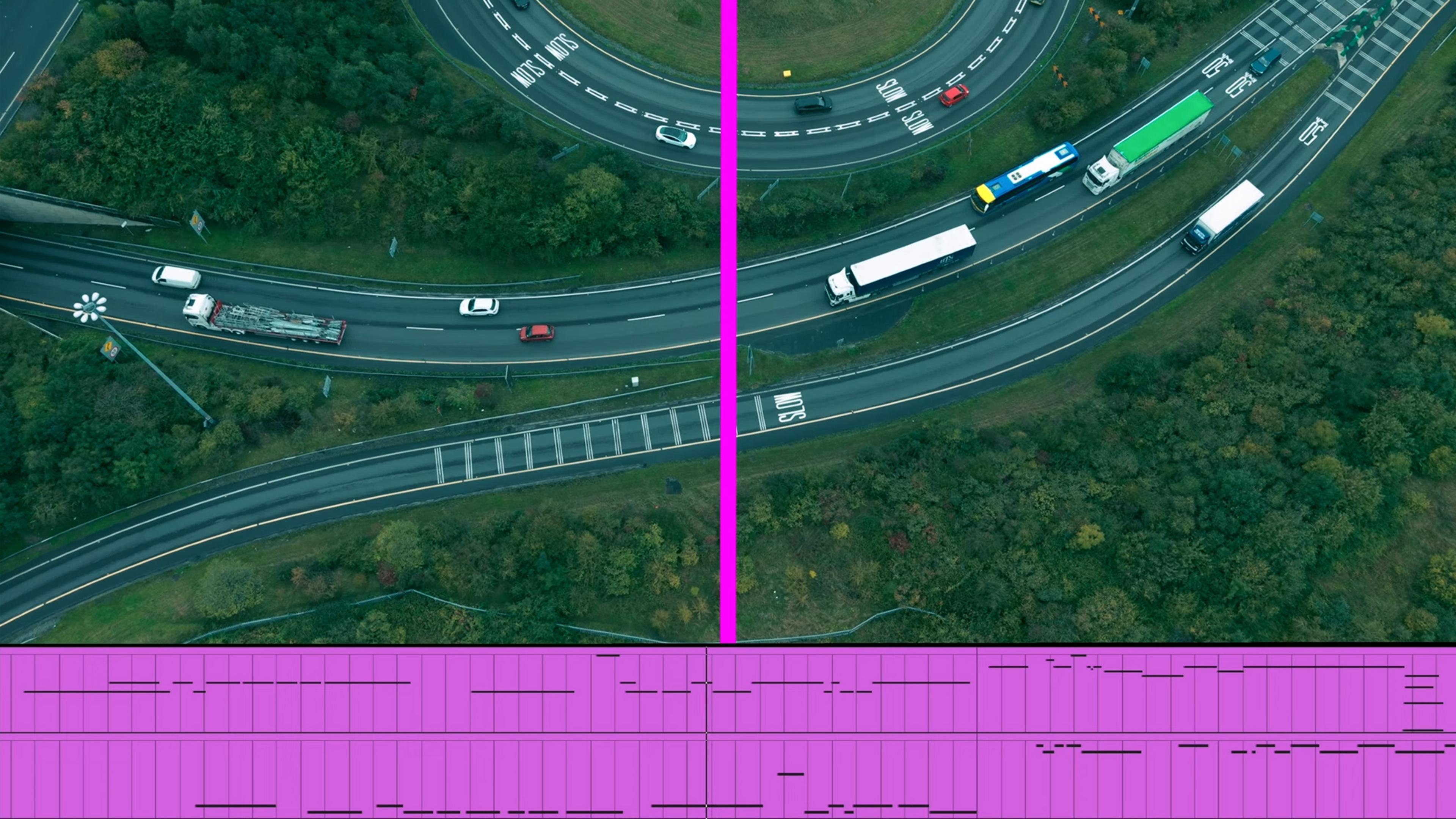 Aerial view of a motorway intersection split by a pink line with abstract purple patterns below, in a photo.